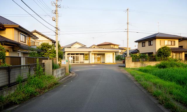 糸田町の住宅地に続く道路と地域施設、暮らしに関する情報を伝える取材風景